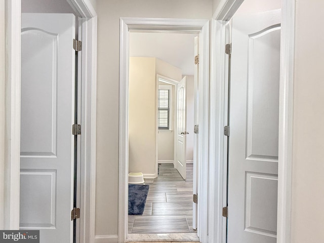 hall featuring baseboards and wood finished floors