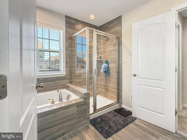 full bath featuring a stall shower, baseboards, and a garden tub