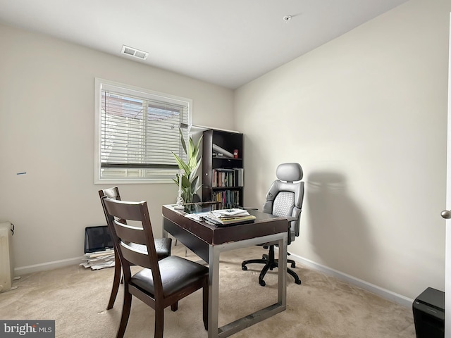 home office featuring visible vents, baseboards, and light colored carpet