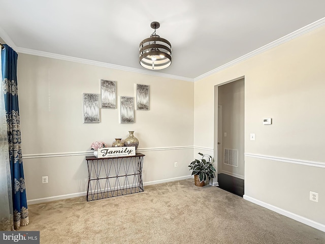 carpeted empty room featuring visible vents, crown molding, and baseboards