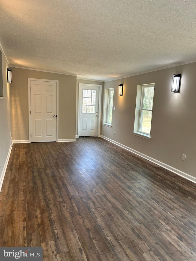 unfurnished room featuring a healthy amount of sunlight, crown molding, baseboards, and dark wood-style flooring