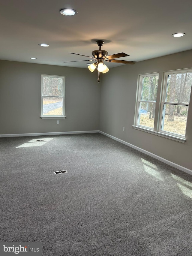 carpeted empty room featuring recessed lighting, visible vents, baseboards, and plenty of natural light