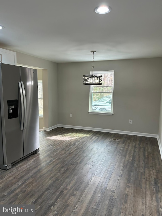 unfurnished dining area featuring a wealth of natural light, baseboards, and dark wood-style floors