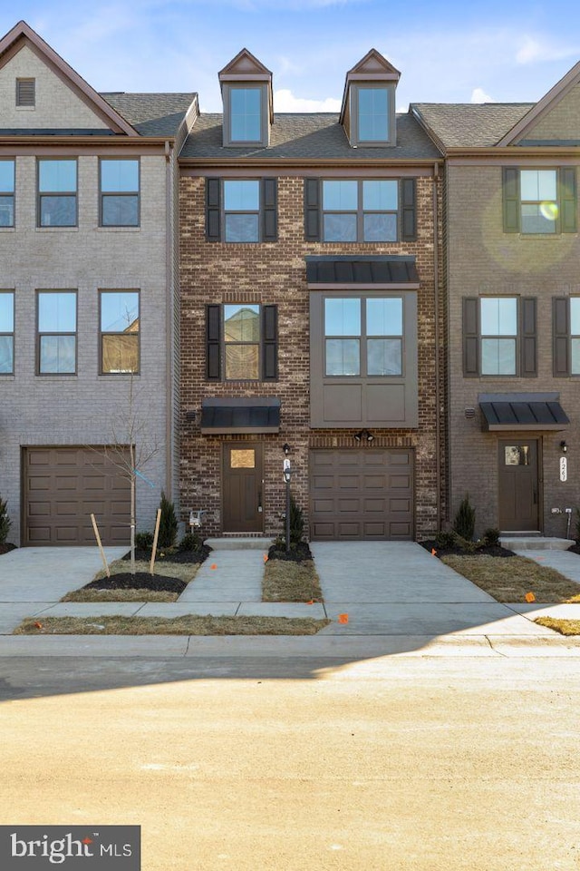 multi unit property with a garage, brick siding, and concrete driveway