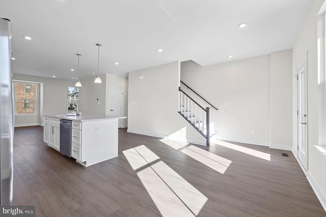 kitchen with a center island with sink, dark wood finished floors, white cabinetry, recessed lighting, and light countertops