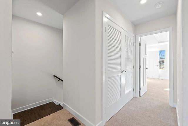 hall with visible vents, carpet, baseboards, an upstairs landing, and recessed lighting