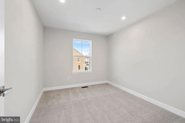 carpeted spare room with recessed lighting, visible vents, and baseboards