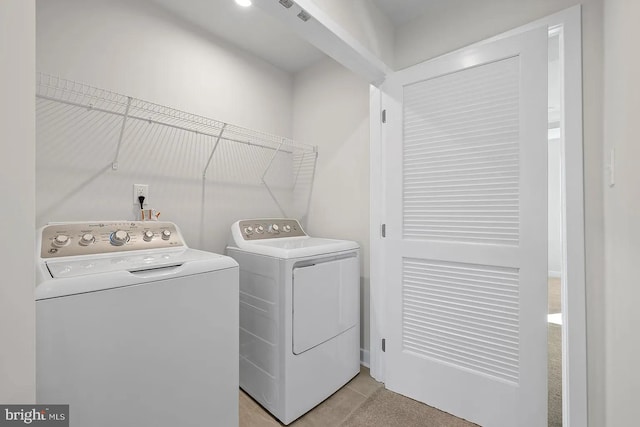 clothes washing area featuring laundry area, light tile patterned flooring, visible vents, and washing machine and clothes dryer