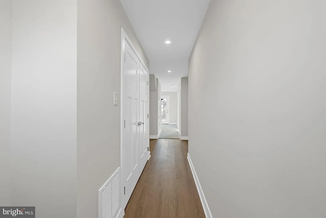 corridor featuring recessed lighting, visible vents, baseboards, and dark wood-type flooring