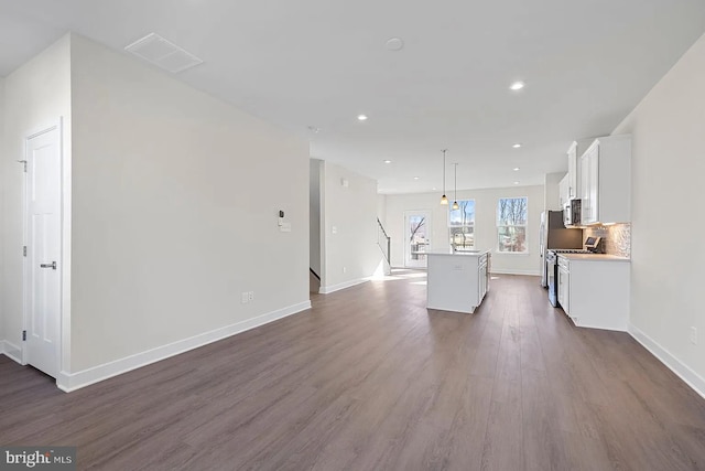 unfurnished living room featuring dark wood finished floors, recessed lighting, and baseboards