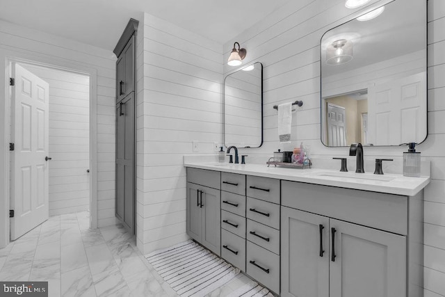 full bathroom featuring marble finish floor, double vanity, and a sink