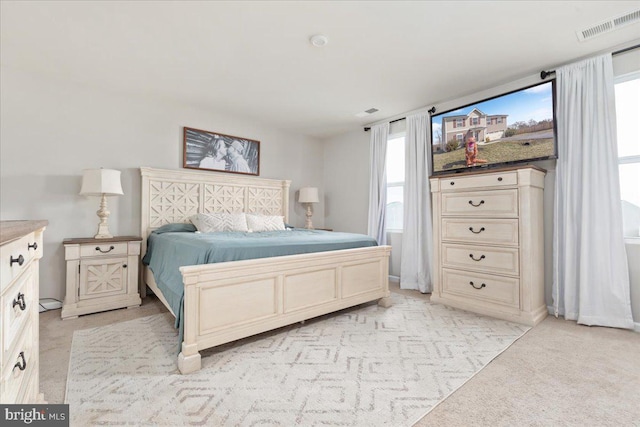 bedroom with visible vents and light colored carpet