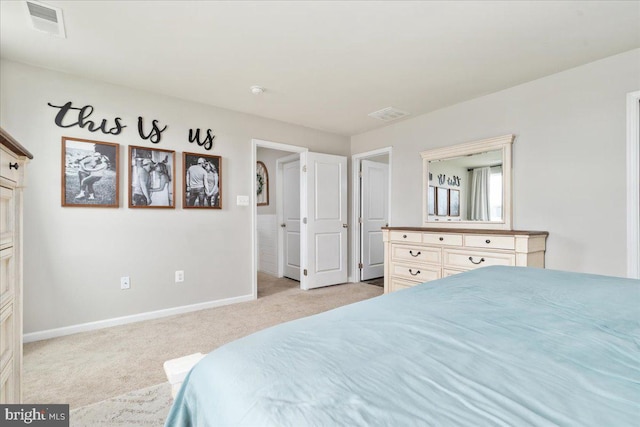 bedroom with baseboards, visible vents, and light colored carpet