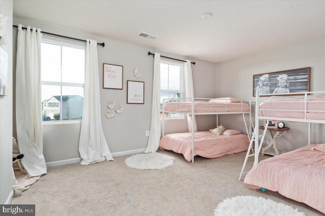 carpeted bedroom with baseboards, multiple windows, and visible vents