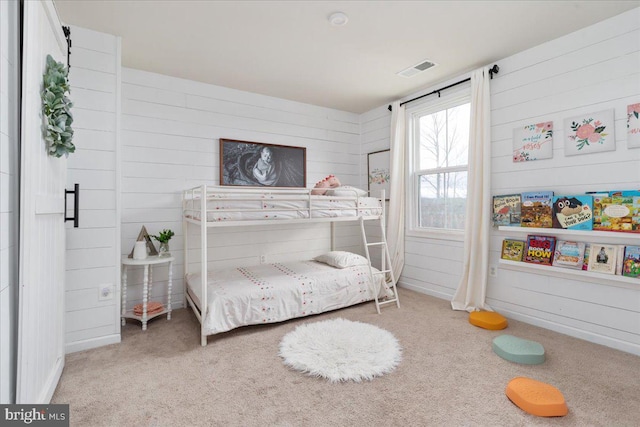 bedroom featuring carpet, visible vents, and wooden walls