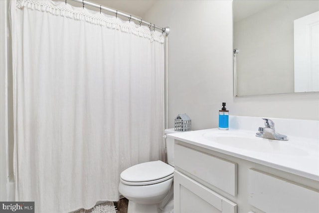 full bath featuring toilet, curtained shower, and vanity