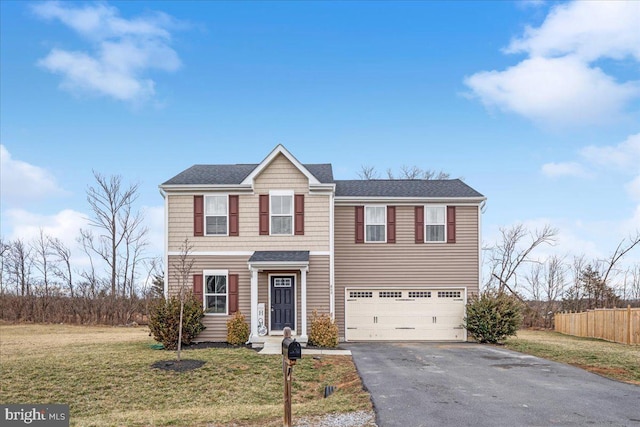 traditional home featuring roof with shingles, fence, a garage, driveway, and a front lawn