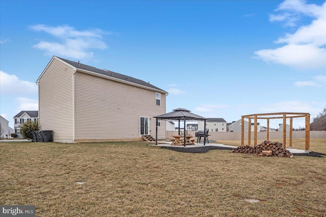 view of side of home featuring a yard, fence, a patio, and a gazebo