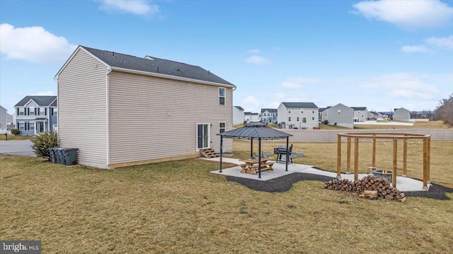 rear view of property featuring a patio area, a yard, and a gazebo