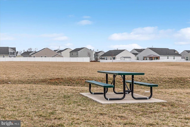 view of home's community with a residential view, fence, and a lawn