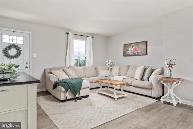 living room with light wood-type flooring and baseboards