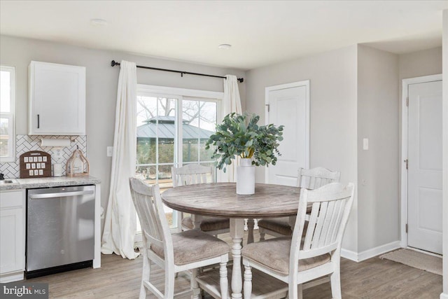 dining room featuring light wood-style floors and baseboards