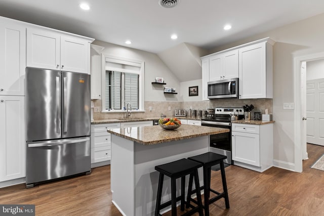 kitchen featuring stainless steel appliances, dark wood-style flooring, a sink, and white cabinetry