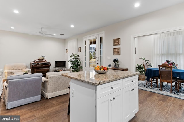 kitchen featuring a center island, dark wood-style flooring, recessed lighting, open floor plan, and white cabinetry