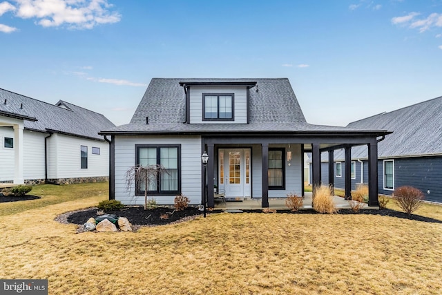 view of front of house featuring a porch, a front yard, and a shingled roof