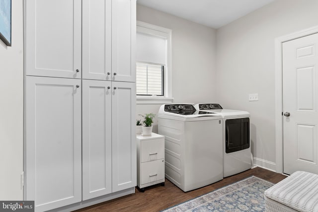 laundry room featuring washing machine and dryer, dark wood-style flooring, cabinet space, and baseboards