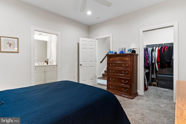 bedroom featuring light carpet, ensuite bathroom, a sink, a spacious closet, and a closet