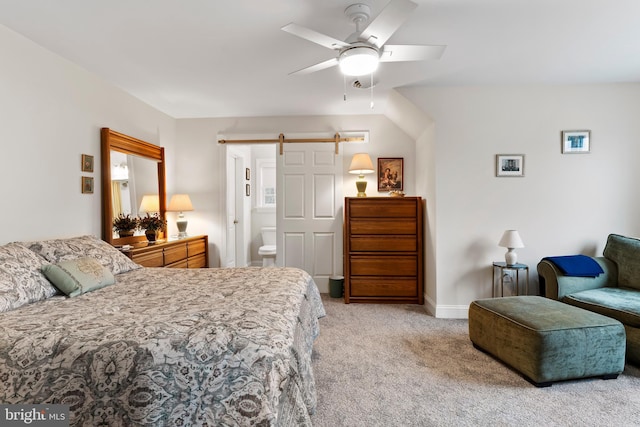 bedroom featuring light carpet, a barn door, baseboards, a ceiling fan, and connected bathroom