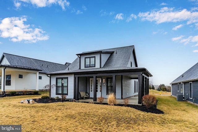 view of front of house with central AC unit, a porch, a front yard, and a shingled roof