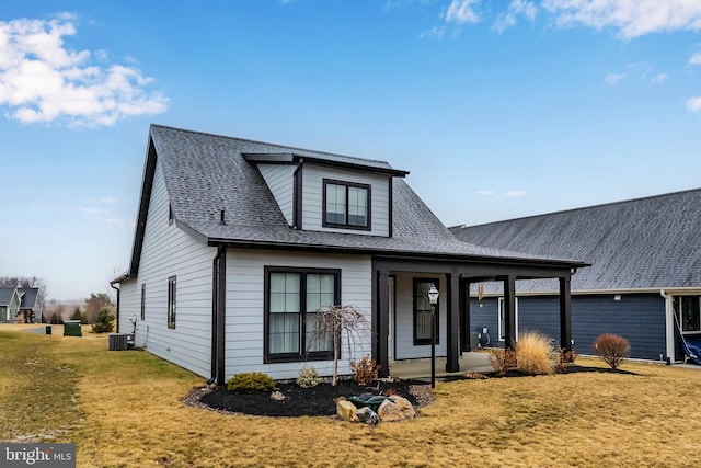 view of front of home featuring central air condition unit, a shingled roof, and a front lawn