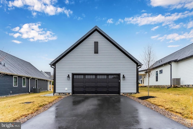 view of property exterior with a garage, driveway, cooling unit, and a yard