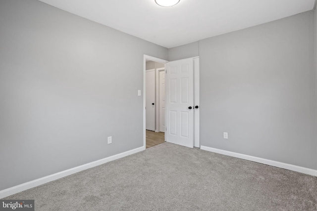 carpeted spare room with baseboards