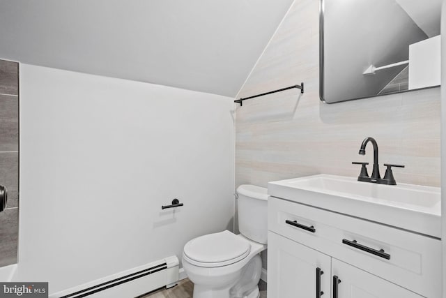 bathroom featuring lofted ceiling, toilet, a baseboard heating unit, vanity, and wood finished floors