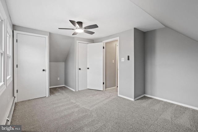 additional living space featuring a baseboard radiator, carpet flooring, lofted ceiling, and baseboards