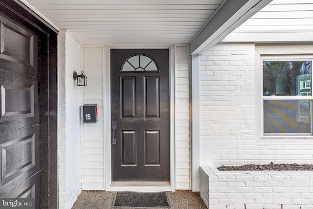 view of exterior entry with brick siding