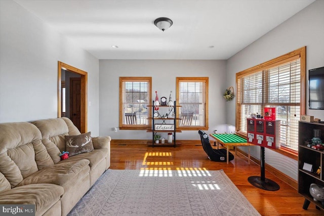 living room featuring a healthy amount of sunlight, baseboards, and wood finished floors