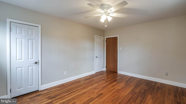 empty room with ceiling fan, baseboards, and wood finished floors