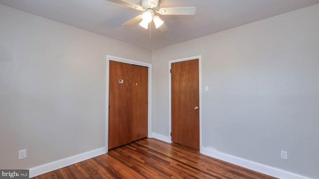 spare room featuring a ceiling fan, baseboards, and dark wood-style flooring