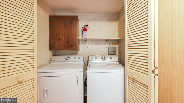 washroom featuring washer and dryer and cabinet space