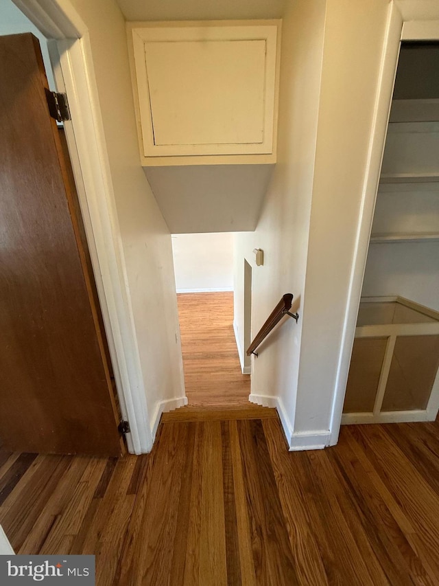 stairs with wood finished floors and baseboards