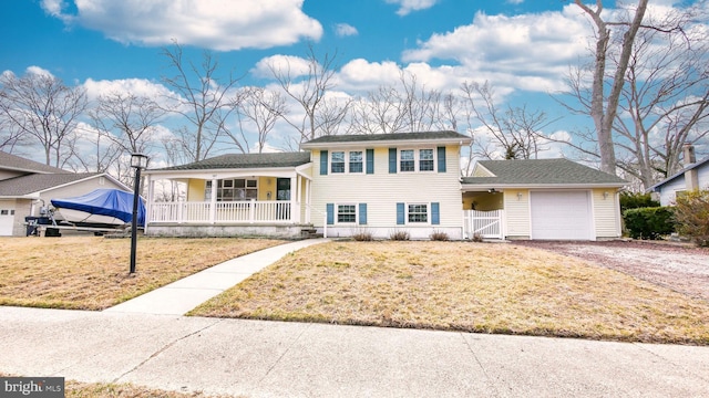 split level home featuring a front lawn, a porch, driveway, an attached garage, and a gate