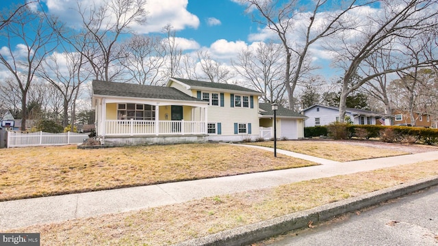 tri-level home with a garage, a porch, a front yard, and fence