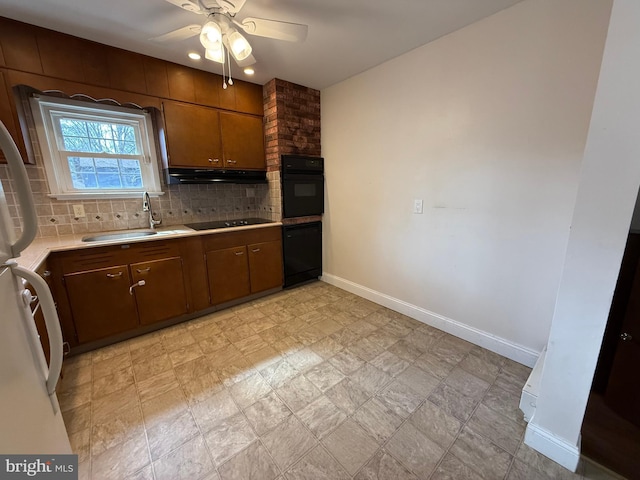 kitchen with black appliances, a sink, under cabinet range hood, backsplash, and light countertops