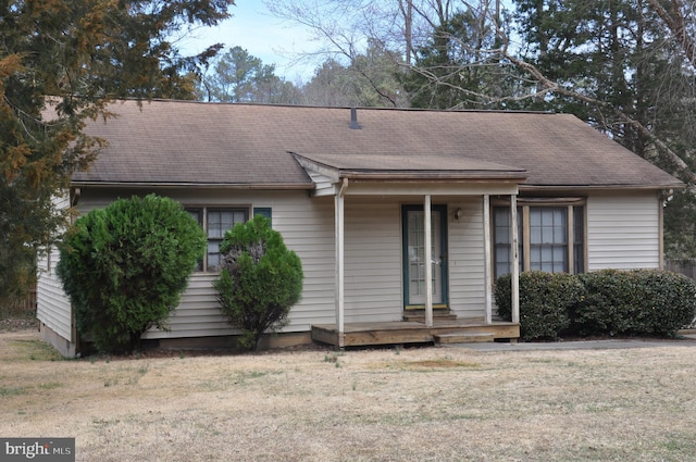 ranch-style home featuring a shingled roof, french doors, and a front lawn