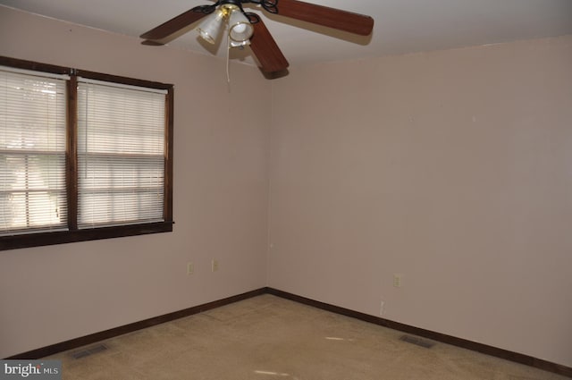 empty room with light carpet, visible vents, and baseboards