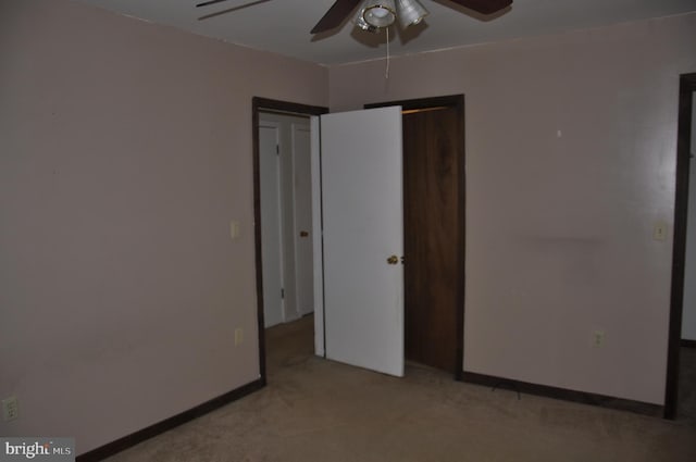 unfurnished bedroom featuring a ceiling fan, light colored carpet, and baseboards